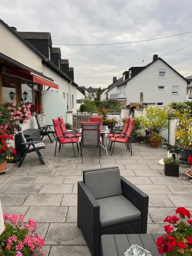 a patio with red chairs and a table and chairs at Gästehaus Elisabeth Bach in Mehring