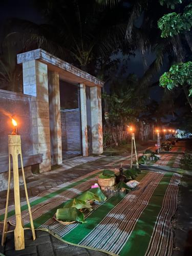 a room with a green rug in front of a building at night at Gemyah in Banyuwangi