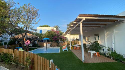 a backyard with a swimming pool and an umbrella at Lakki Village in Aegiali