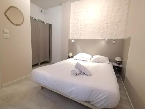 un lit blanc avec deux serviettes dessus dans l'établissement L'Escapade - Hypercentre - Cœur Piéton à 50m, à Pau