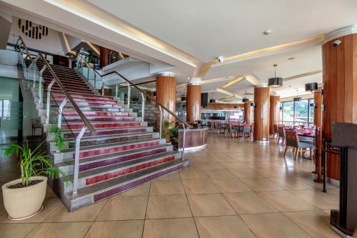 a lobby of a restaurant with stairs and tables at Sterling Mussoorie in Mussoorie