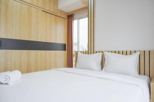 a bedroom with two white beds and a window at Homey and Cozy Designed 2BR at Tokyo Riverside PIK 2 Apartment By Travelio in Rawalembang