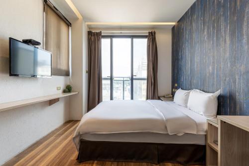 a hotel room with a large bed and a tv at CHECK inn Express Taichung FuXing Hall 2 in Taichung
