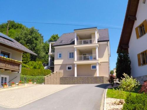 a large white house with a driveway at Apartment Adlerhorst - Schwalbenhof Farm in Haselbach