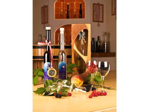 a table with wine bottles and wine glasses on it at Apartment Adlerhorst - Schwalbenhof Farm in Haselbach