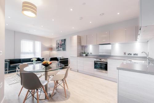 a kitchen and living room with a table and chairs at Roomspace Serviced Apartments - Vertex House in Croydon