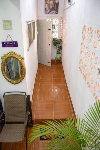 a hallway with wooden floors and a mirror at Roses Place in Brown Hill Village