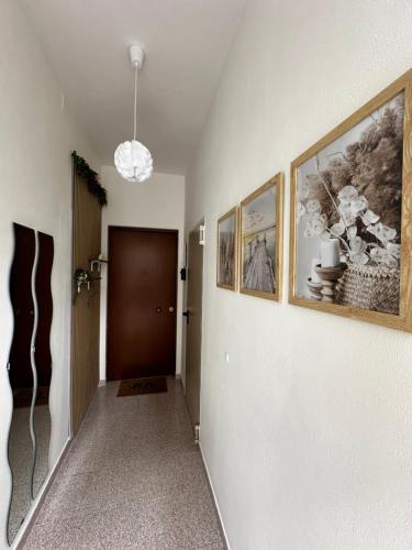 a hallway with two pictures on the wall and a door at Civico 56 in Verona