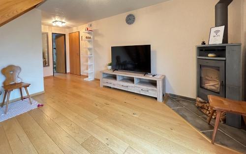 a living room with a television and a fireplace at 'DAHElM' in Hofstetten 
