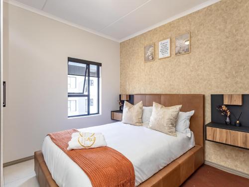 une chambre avec un grand lit et une fenêtre dans l'établissement Anna Suite - Serenity & Stuff Luxury Apartments, à Midrand