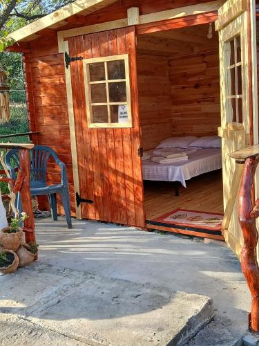 a wooden cabin with a bed and a door at CABANE Nadejda SPERANTA in Găgeni