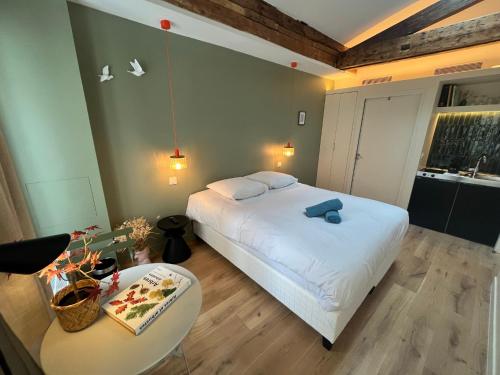 une chambre avec un grand lit blanc et une table dans l'établissement Saint Jacques Luxembourg, à Paris