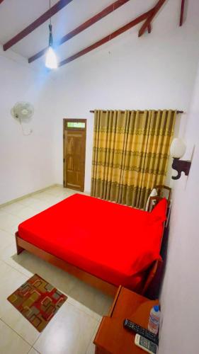 a bedroom with a red bed in a room at White Eagle Hotel in Sigiriya