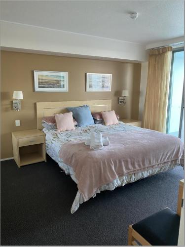a bedroom with a large bed with pink and blue pillows at Pool View Retreat in Ballina