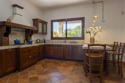 a kitchen with wooden cabinets and a large window at Villa Stella in Marsala