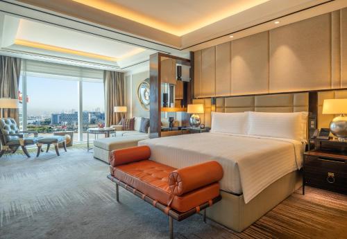 a bedroom with a large bed and a living room at Solaire Resort Entertainment City in Manila
