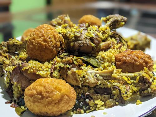 a plate of food with rice and meatballs at White Eagle Hotel in Sigiriya