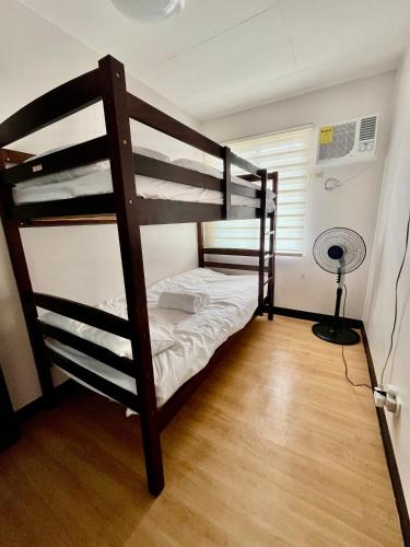 two bunk beds in a room with a fan at Soccour Homestay by ekc in Marilao