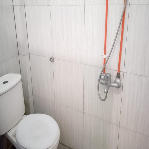カラワンにあるAcintyya Homestay Syariah RedPartnerのトイレとシャワー付きのバスルーム