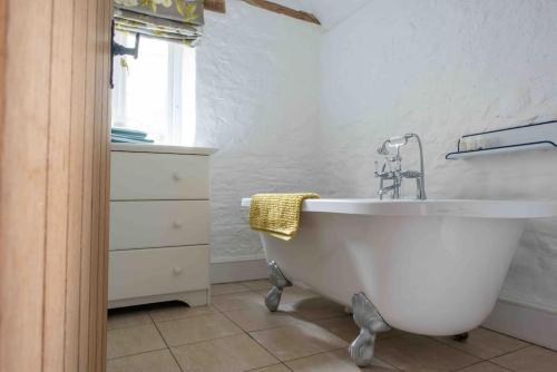 a white bath tub in a bathroom with a window at The Granary, Barwick in Yeovil