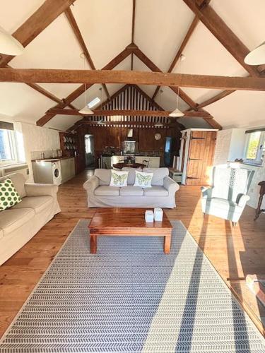 a living room with couches and a coffee table at The Granary, Barwick in Yeovil