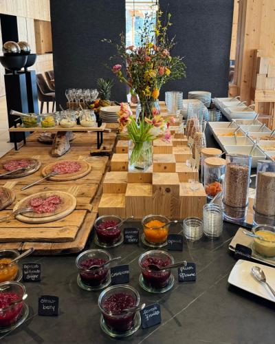 een lange tafel gevuld met borden en kommen van voedsel bij Tenne Chalets in Racines