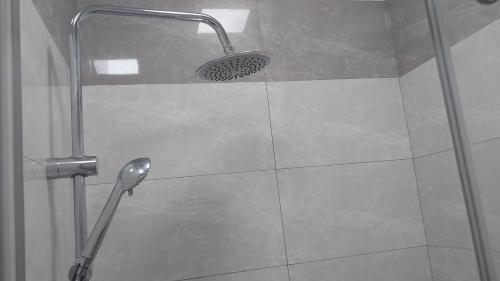 a shower with a shower head in a bathroom at Banu House in Sumqayyt