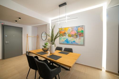 a dining room with a wooden table and chairs at VersusArtSuites in Serres