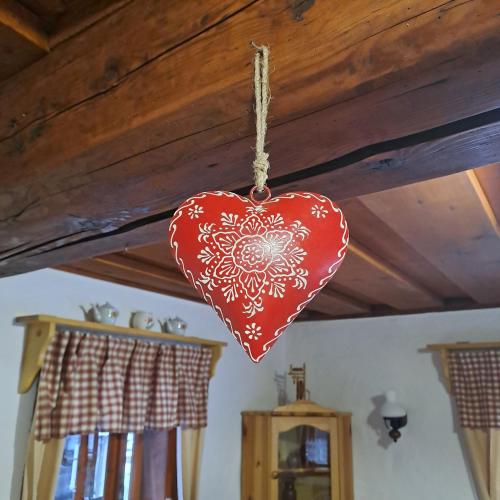 a red heart ornament hanging from a ceiling at Drevenica pod Lánom in Zuberec