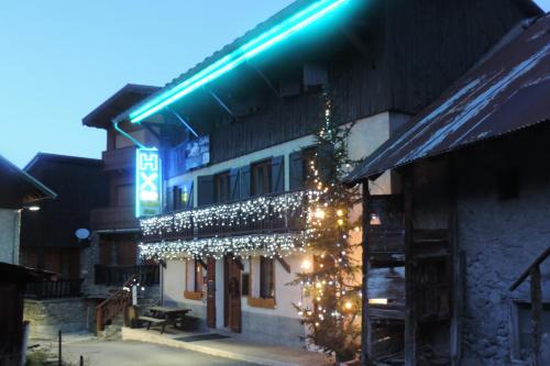 a building with a christmas tree and lights on it at Hôtel Le Lievre Blanc in Vars