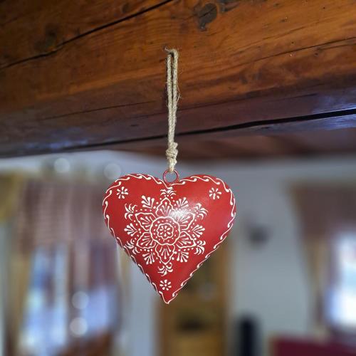 a red heart ornament hanging from a ceiling at Drevenica pod Lánom in Zuberec