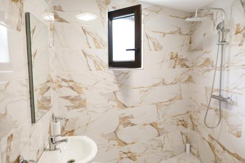 a white bathroom with a sink and a window at Domeniul Roa in Avrig