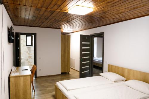 a bedroom with a bed and a wooden ceiling at Domeniul Roa in Avrig