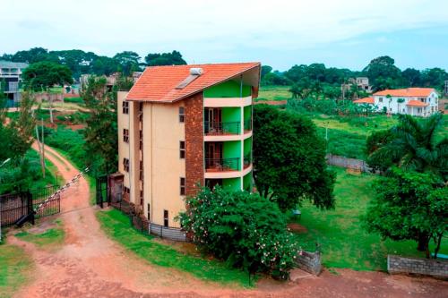 a building with a red roof on a field at Sky Beach Hotel in Wakiso