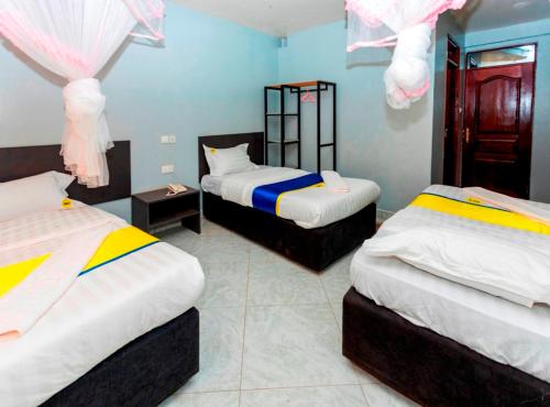 a room with two beds with pink and blue at Sky Beach Hotel in Wakiso