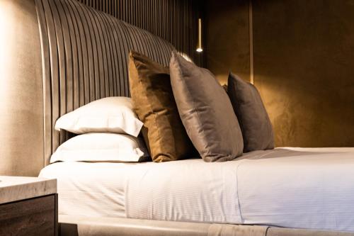 a bed with a bunch of pillows on it at LE RÊVE DE NAIM Roma in Rome