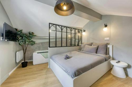 une chambre avec un lit et une plante en pot dans l'établissement The Duplex spa Paris, à Bagnolet