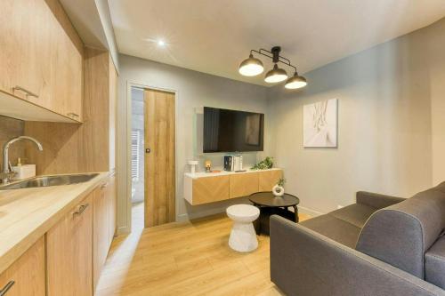 a kitchen and living room with a couch and a table at The Duplex spa Paris in Bagnolet