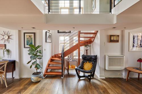 a living room with a staircase and a chair at Deco Loft on Russell Street in Melbourne