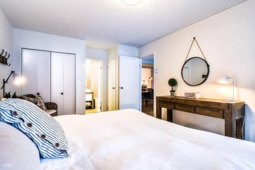 a bedroom with a bed with a mirror and a desk at Chic Mt-Tremblant Condo with View on the Lake by Denstays in Mont-Tremblant