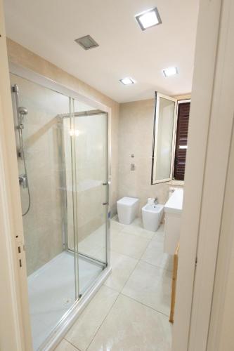 a bathroom with a glass shower and a toilet at Villa delle Muse in Marsala