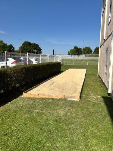 a wooden ramp sitting in the grass next to a building at Fasthotel in Jaux