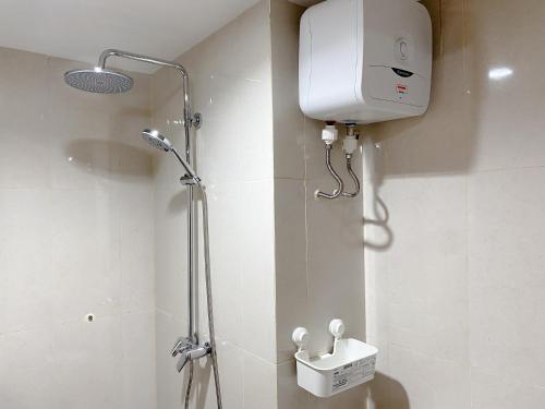 a shower in a bathroom with a toilet and a tank at Good Choice and Cozy Studio Gateway Park LRT City Jatibening Apartment By Travelio in Bekasi