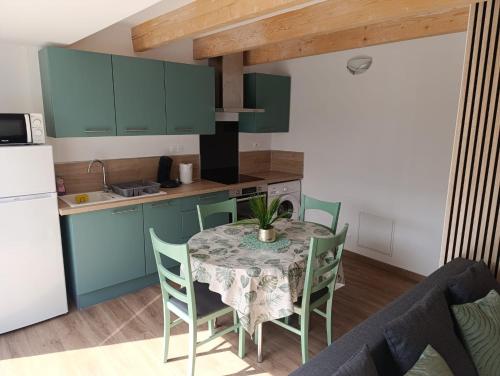 une cuisine avec une table et des chaises dans une cuisine dans l'établissement Maison Duplex, à Pierrelatte