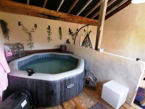 a bath tub in a room with a wooden floor at Chambre d'hôtes 1 - Rétro - Un Refuge à Cachen in Cachen