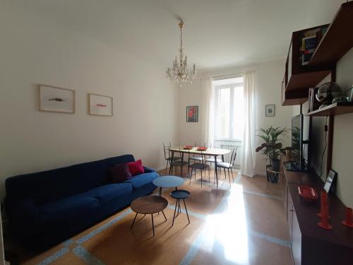 a living room with a blue couch and a table at Design House Monti in Rome