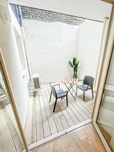 un patio avec deux chaises et une table sur un balcon dans l'établissement Cosy Sun - 1CH - avec patio privatif, à Pau