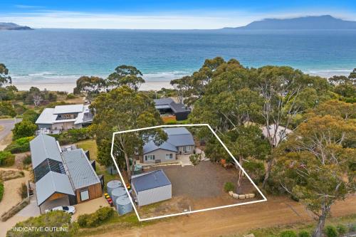 an aerial view of a house with the ocean in the background at Sea views at Spring Beach Tasmanias East Coast in Spring Beach