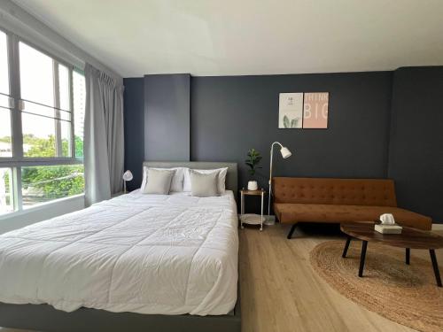 a bedroom with a large bed and a table at Baan Peang Ploen Takiab Beach by Cloud9Stays in Hua Hin