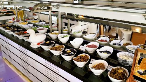 アンタルヤにあるブルー ガーデン ホテルの食べ物やアヒルのボウルが並ぶビュッフェライン